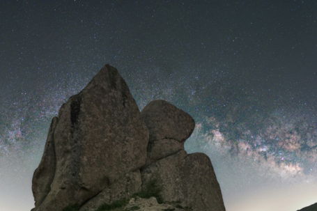 Rocky formation under a starry night sky